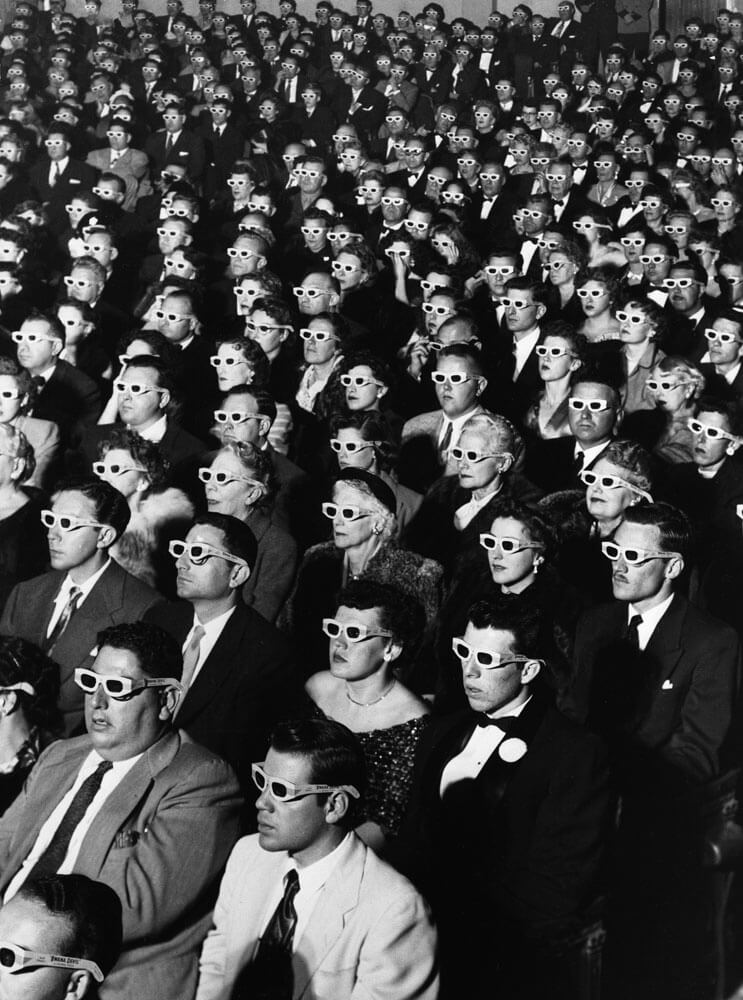 black and white photo of movie audience in the past watching a 3-D movie